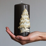 Dunkle Weihnachtskerze mit goldenem Weihnachtsbaum aus Wachs