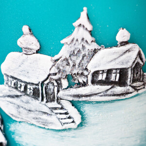 Dicke, türkise Stumpenkerze zu Weihnachten mit einem Wachsmotiv in Handarbeit