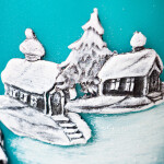 Dicke, türkise Stumpenkerze zu Weihnachten mit einem Wachsmotiv in Handarbeit