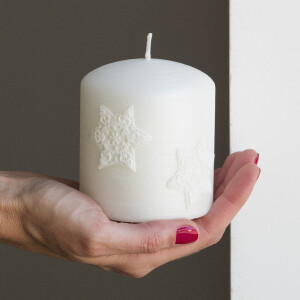 Weiße Weihnachtskerze mit Sterne aus Wachs auf der Rillenkerze