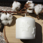 Weiße Weihnachtskerze mit Sterne aus Wachs auf der Rillenkerze