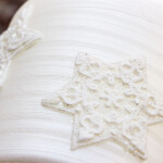 Weiße Weihnachtskerze mit Sterne aus Wachs auf der Rillenkerze